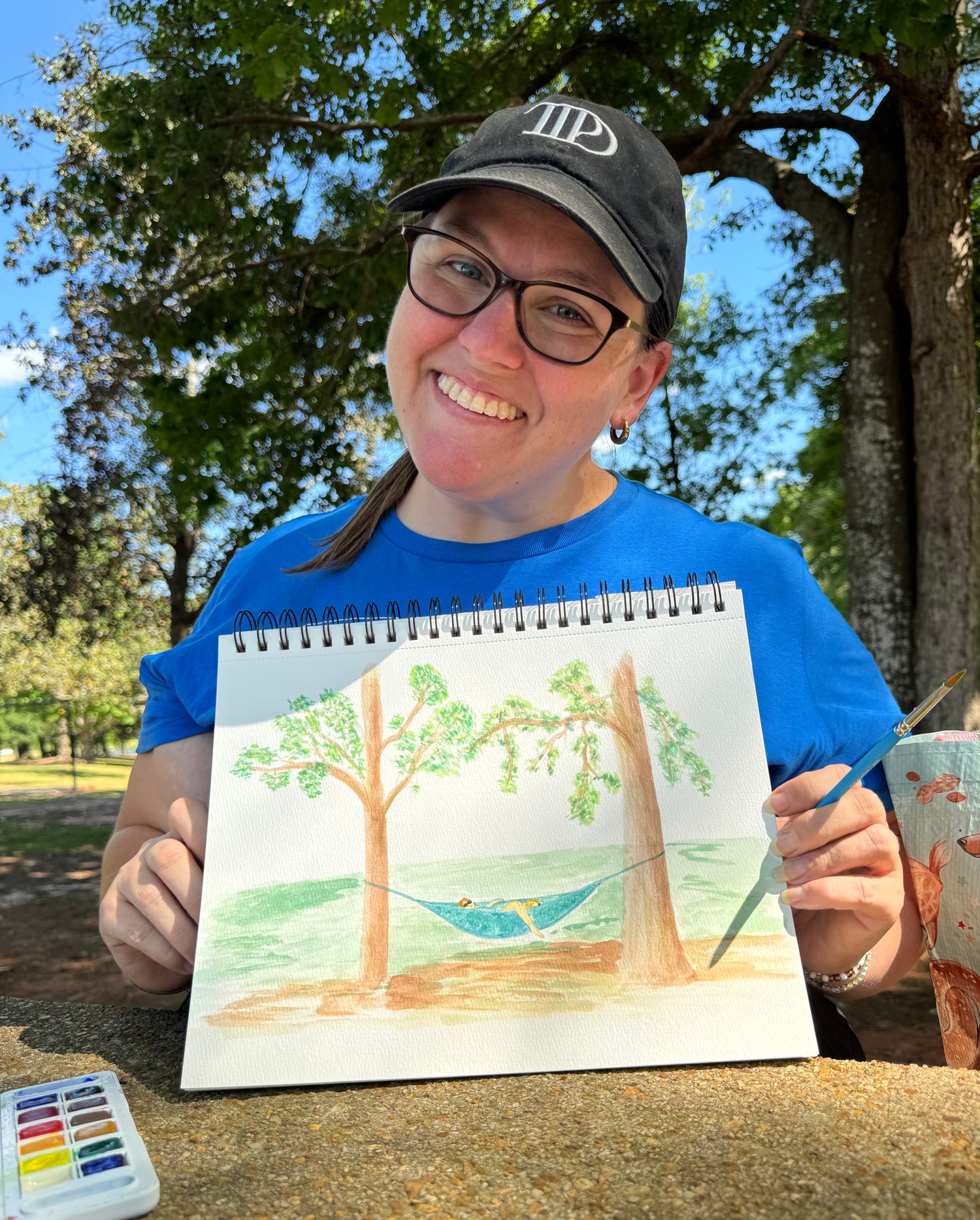 Kelcie Hathcock holding an original watercolor painting in Fort Walton Beach, Florida